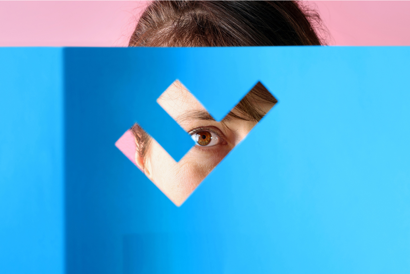 Eine Leserin blickt durch das im Deckblatt des Geschäftsberichts eingestanzte Logo der Flughafenregion Zürich.