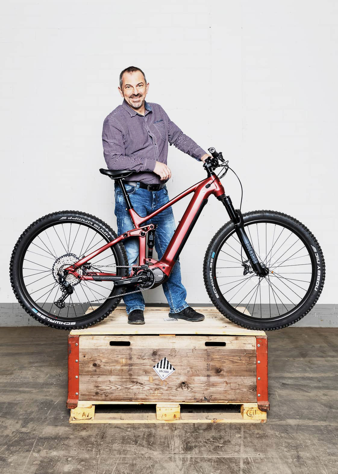 Ein Zibatra-Mitarbeiter steht mit einem Velo auf einem Europalett.