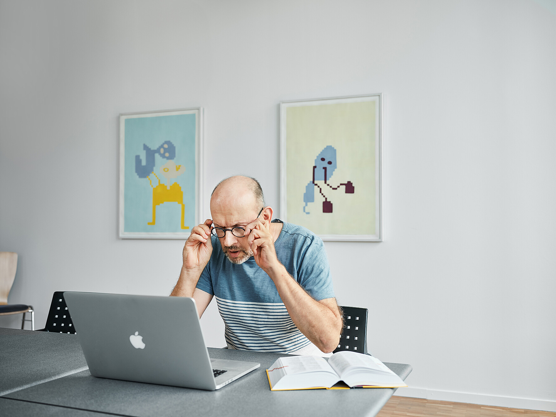 Un correcteur regarde l’écran à travers ses lunettes.