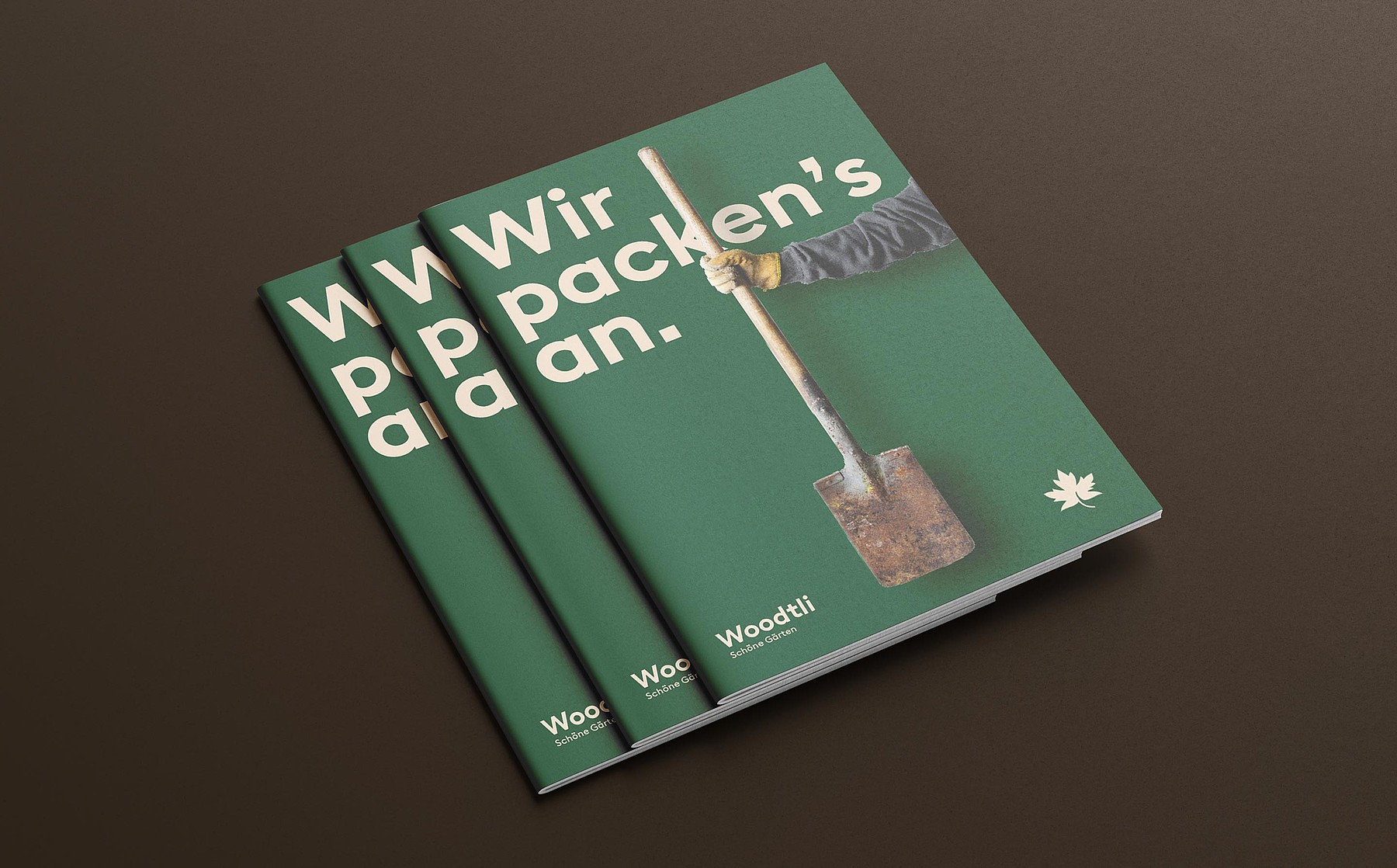 Auf dem grünen Cover einer Woodtli-Werbebroschüre steht: «Wir packen’s an.» Es zeigt eine Hand im Gartenhandschuh mit einer stark verwitterten Gartenschaufel.
