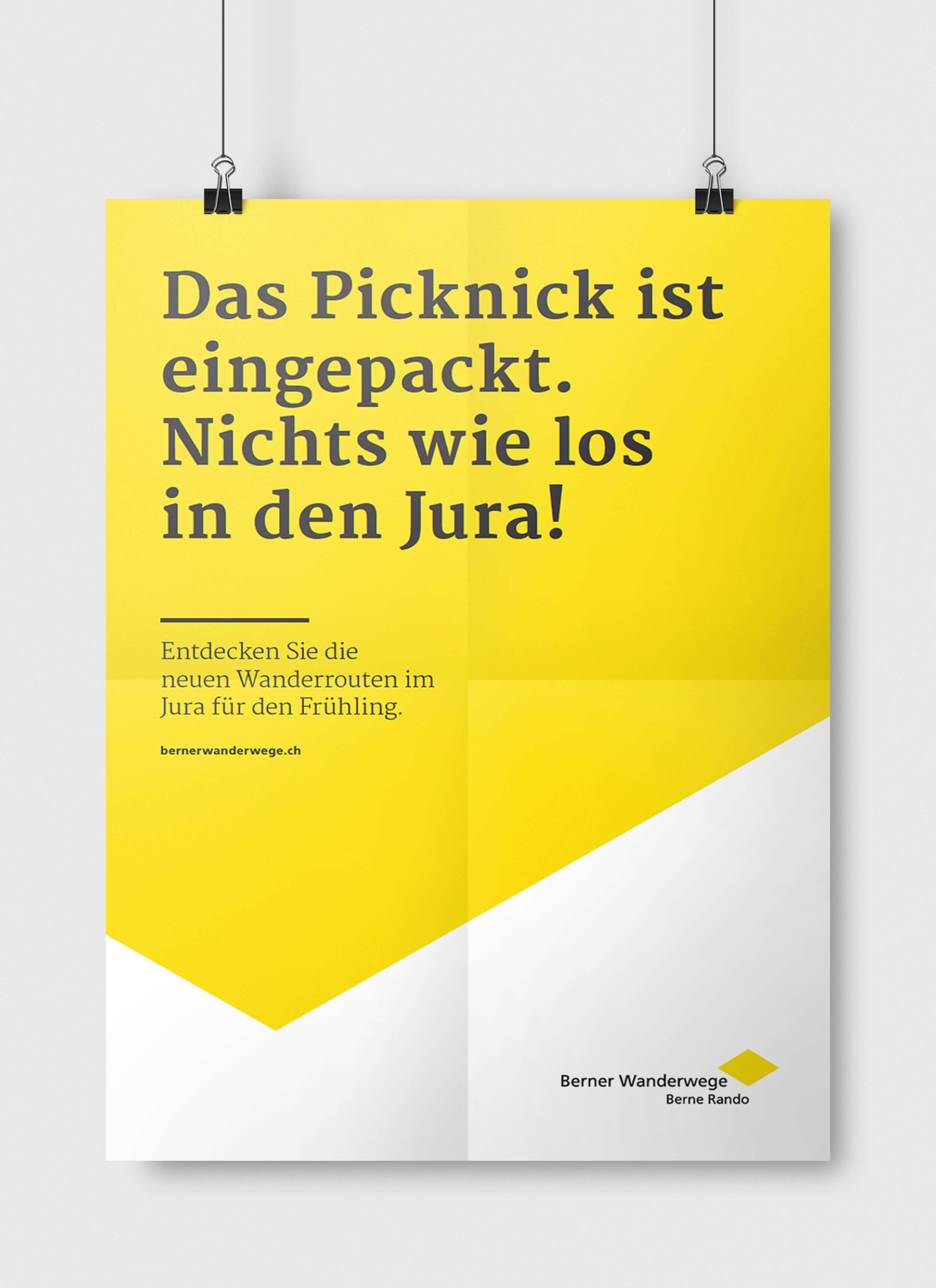 Auf einem gelben Poster der Berner Wanderwege steht: «Das Picknick ist eingepackt. Nichts wie los in den Jura!» Und in kleinerer Schrift darunter: «Entdecken Sie die neuen Wanderrouten im Jura für den Frühling.»