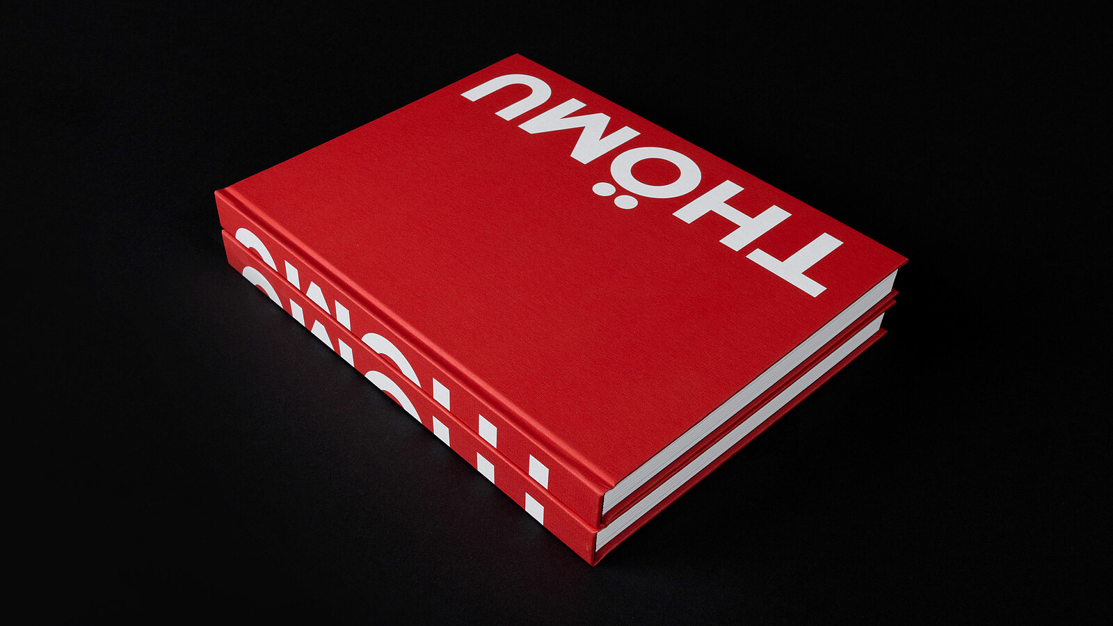 Zwei übereinanderliegende Exemplare des knallroten Buches über den Thömus-Gründer mit dem Titel «Thömu» 