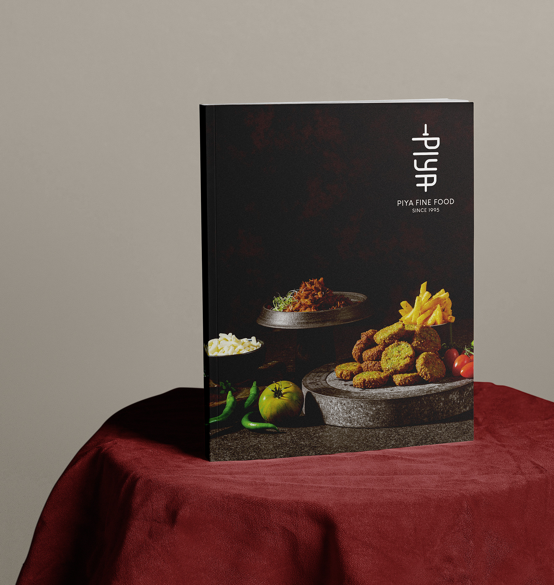 Die elegant schwarz gehaltene Broschüre «PIYA Fine Food since 1995» präsentiert auf einem Tischchen mit rotem Tischtuch.