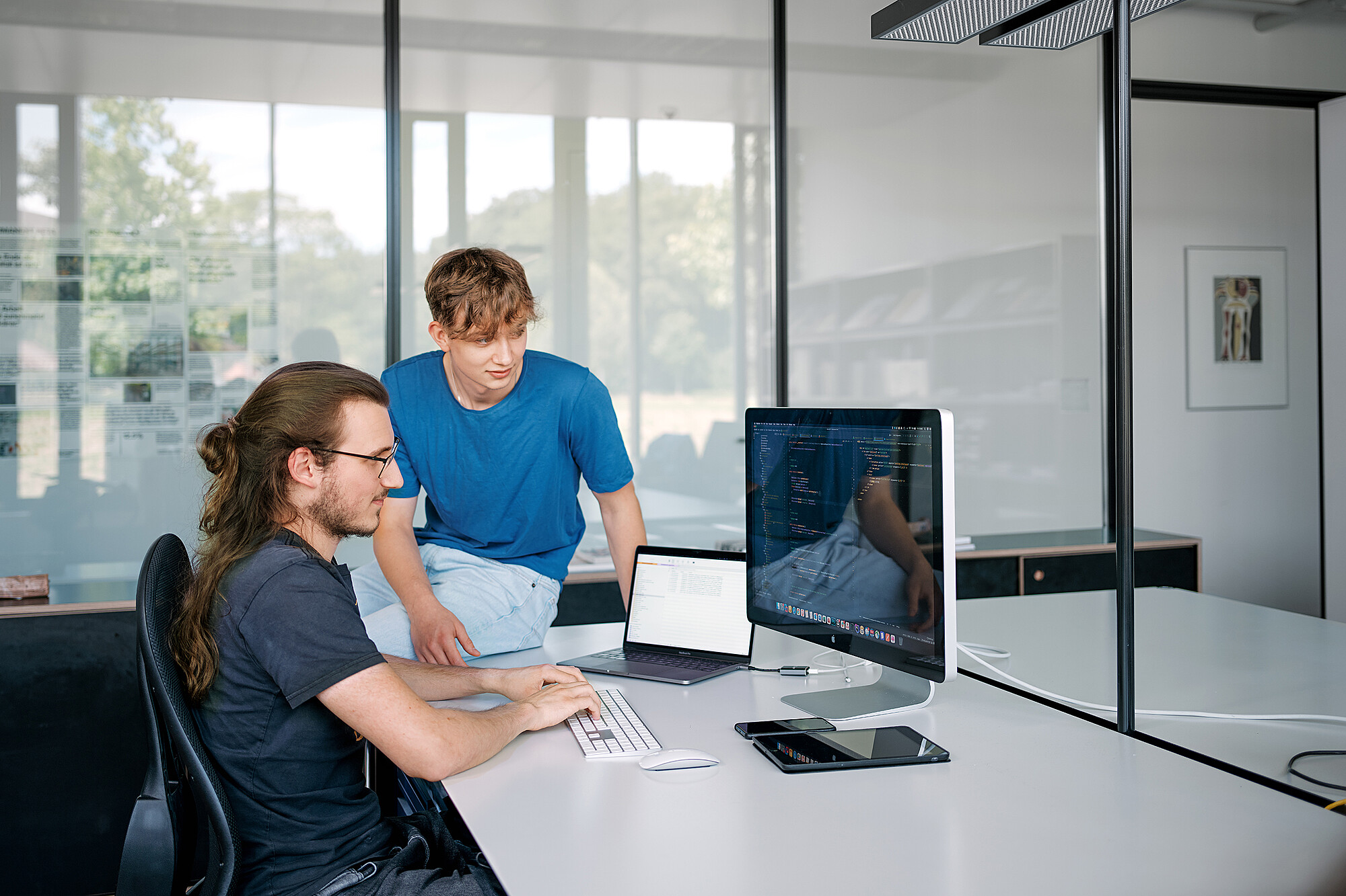 Zwei Mitarbeitende bei der Arbeit am Computer